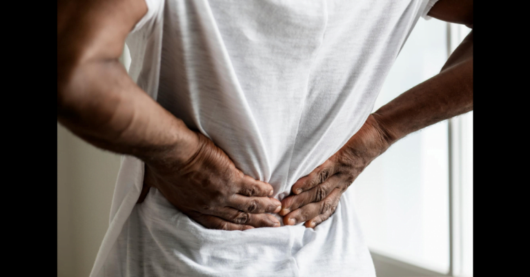 Man holding back due to middle back pain